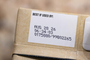 Close up text best before date on carton of broth.