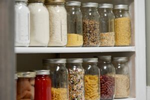 Glass mason jars filled with dried and preserved food goods in a farmhouse pantry