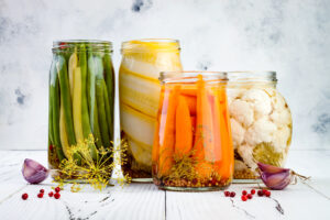 Marinated pickles variety preserving jars. Homemade green beans, squash, carrots, cauliflower pickles. Fermented food.