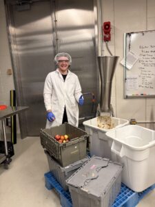 Young adult posing with apples at the start of the process to press apples